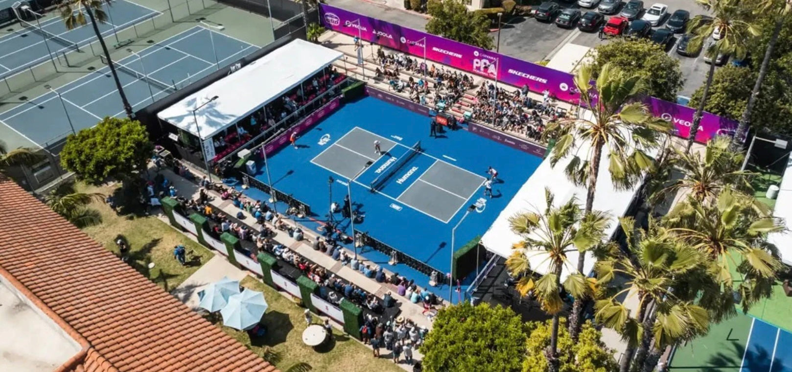 A pickleball court with tennis courts in the background.