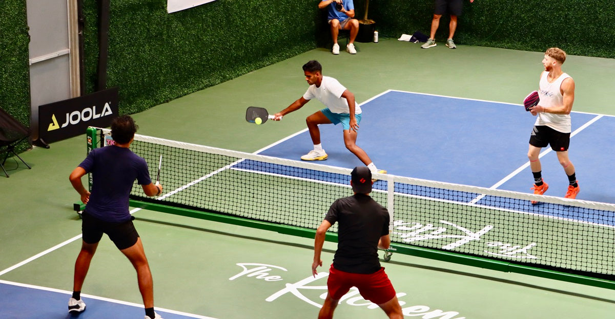 A pickleball player about to apply spin to his next shot.
