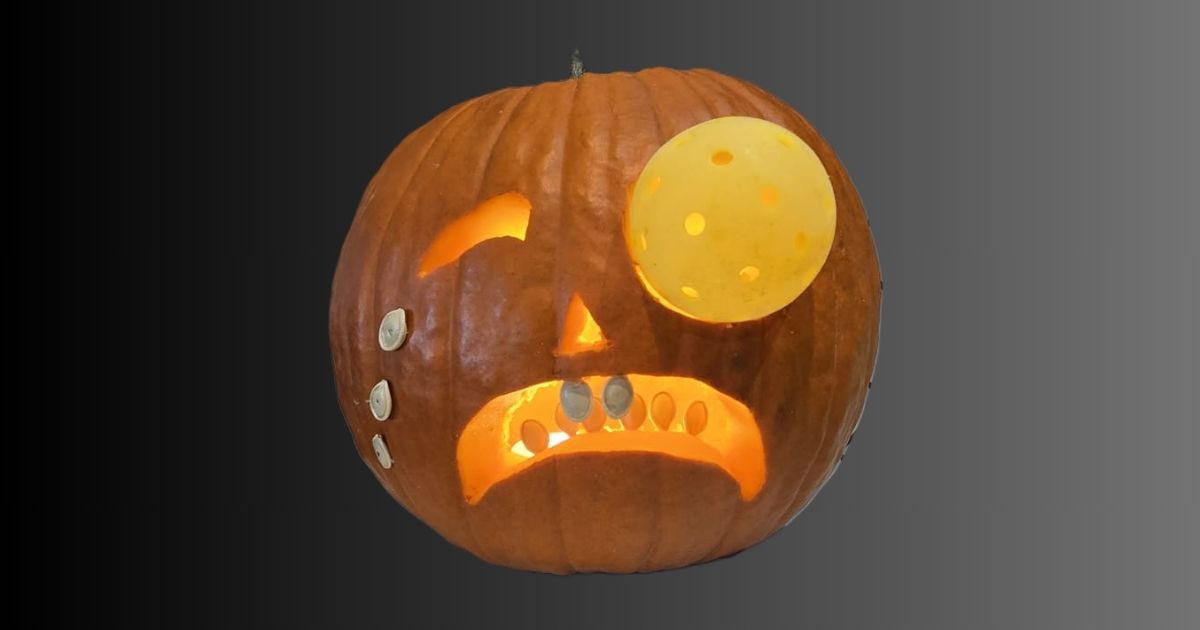 A jack o lantern that's crying pumpkin seeds because it got hit in the "eye" with a pickleball