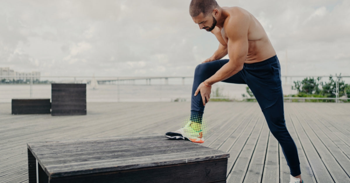 Man stretches leg, looks down at ankle highlighted in pickleball-green