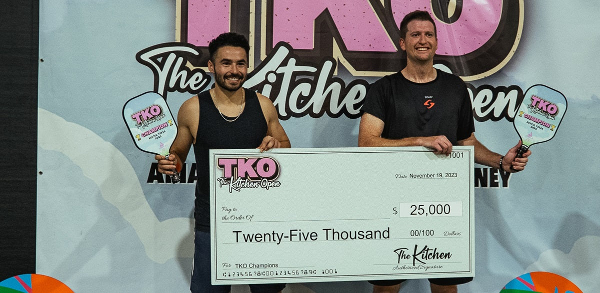 Image from TKO pickleball tournament in 2023 where two winners pose with a giant check