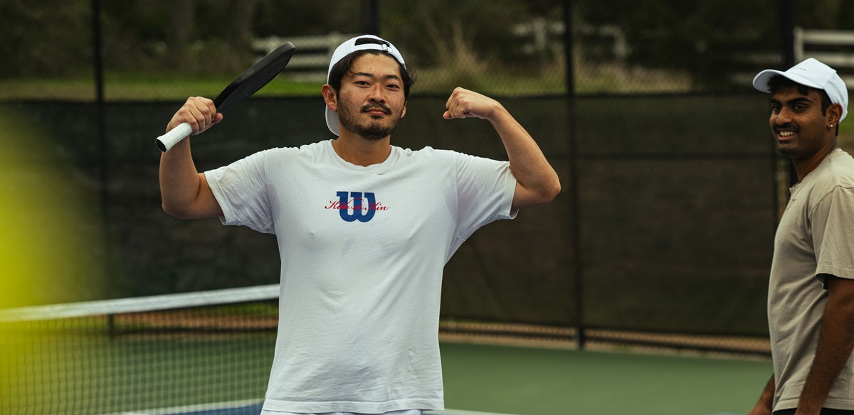 A pickleball player poses with his arms in a "strong" pantomime