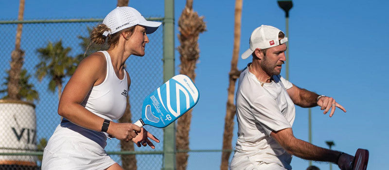 Catherine Parenteau, left, in the middle of a pickleball point with partner Jack Sock, right.
