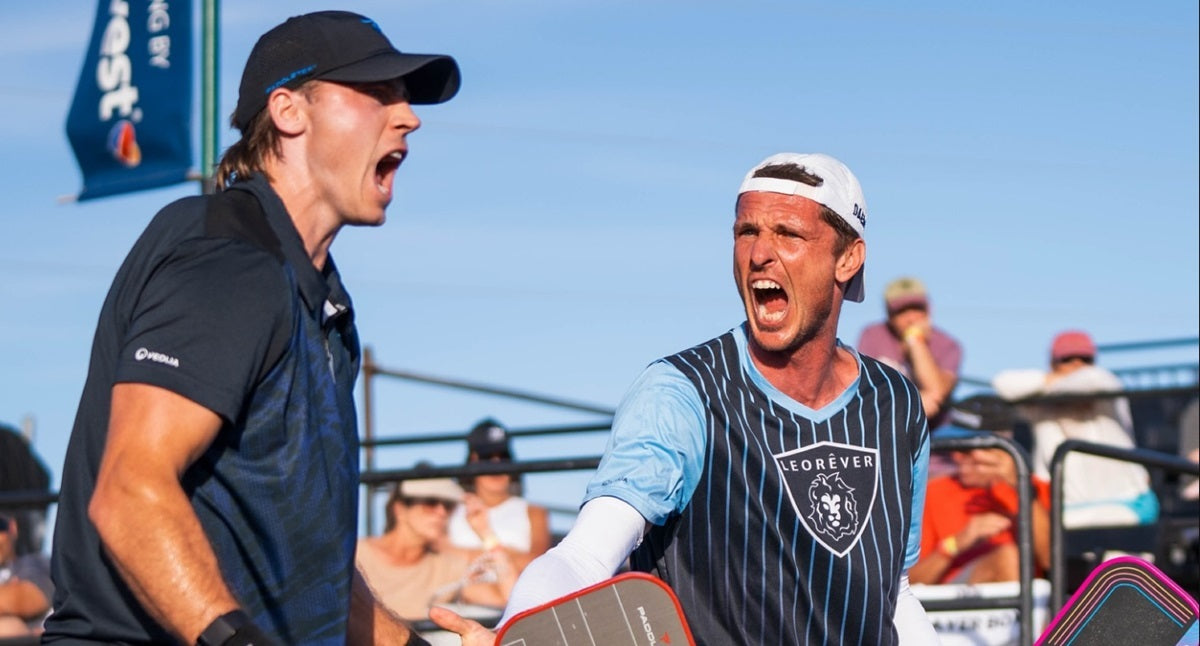 Two pickleball doubles partners celebrating after winning a point.