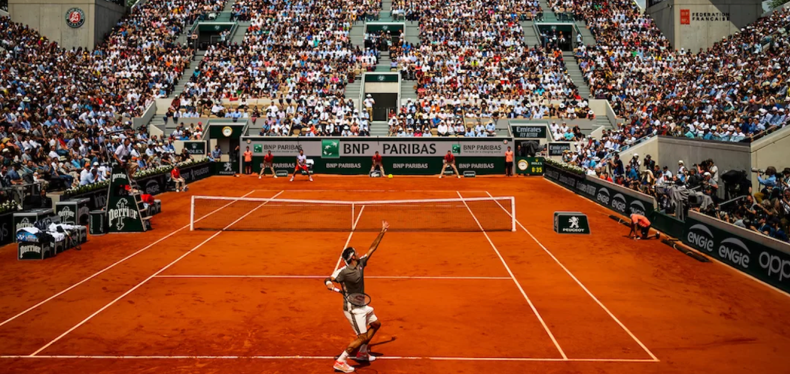 An image taken at a previous French Open of a tennis player about to serve.