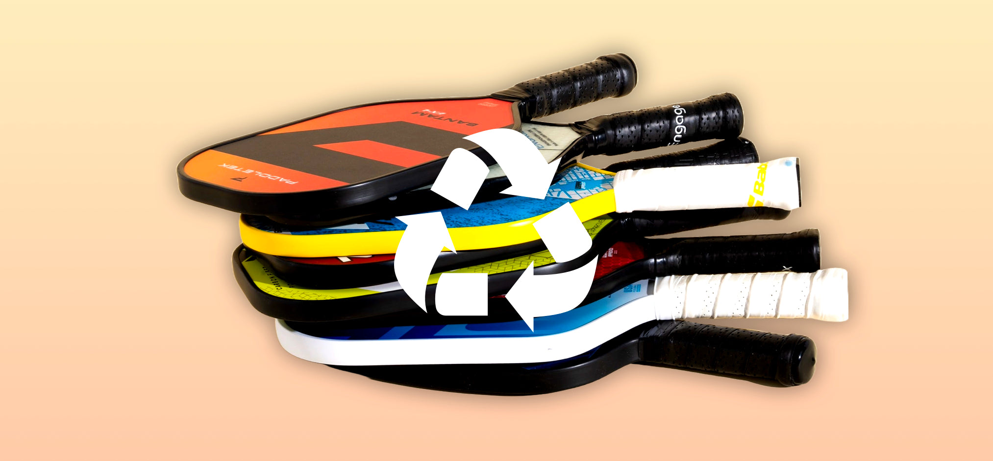 Pickleball paddles can be reused or recycled. Paddles stacked with recycling logo on top.