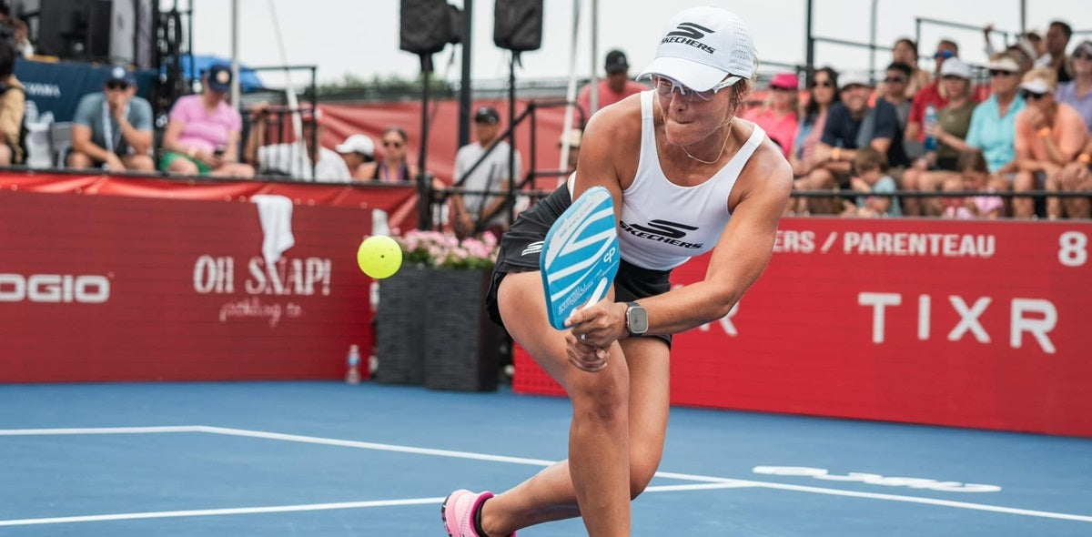 Pickleball player Catherine Parenteau just after making contact with the ball mid-court, in the transition zone