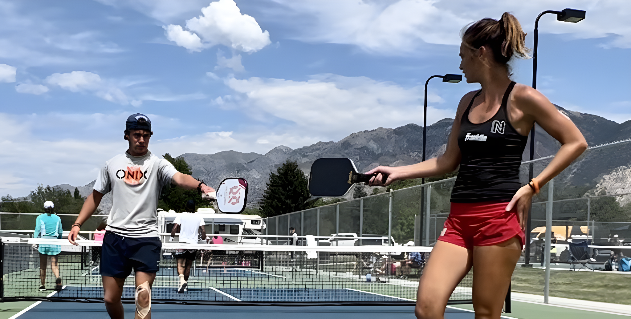 Two pickleball players going in to tap paddles between points