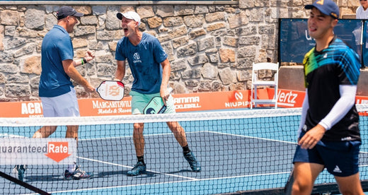 Moment from a PPA tour match where two players on the left celebrate as the opponent on the right moves away.