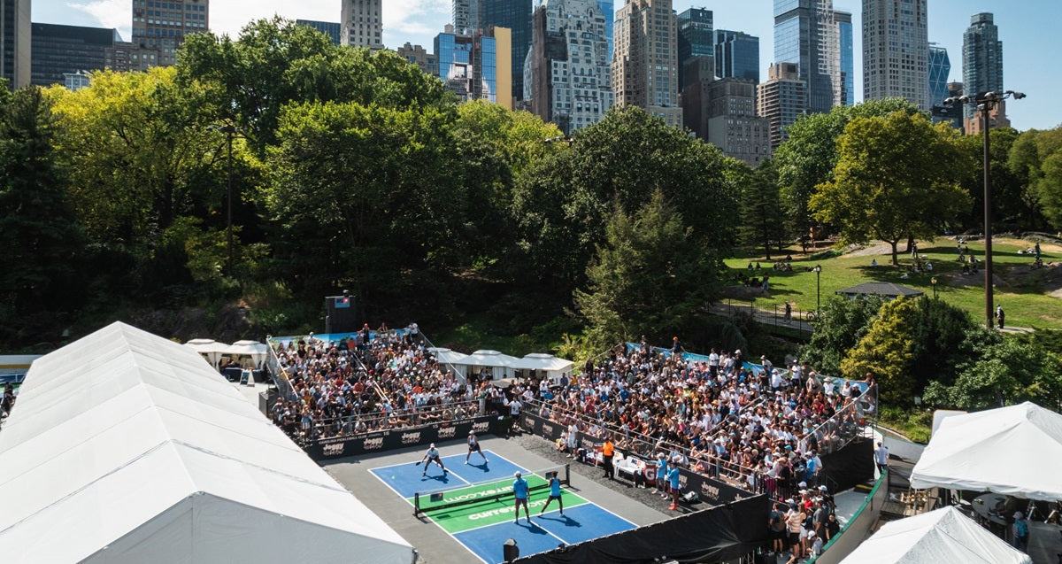 An image of a large crowd observing a professional pickleball game in NYC's Central Park