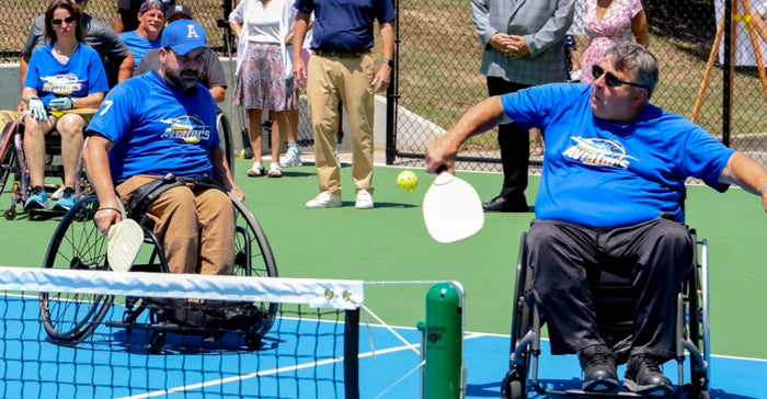 Pickleball players in wheelchairs during a point, playing on an adaptive pickleball court