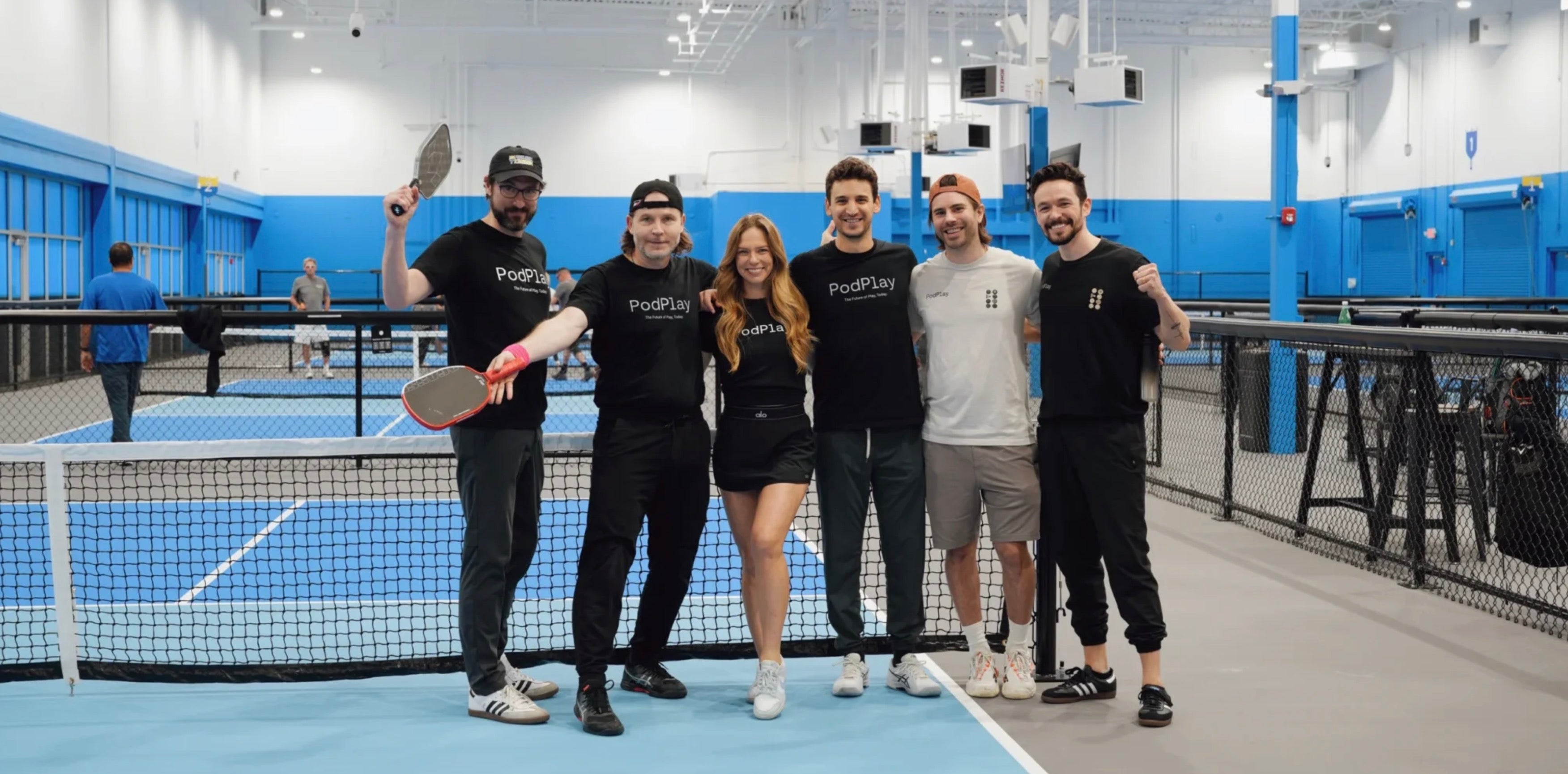 The PodPlay team poses for a photo on the pickleball court.