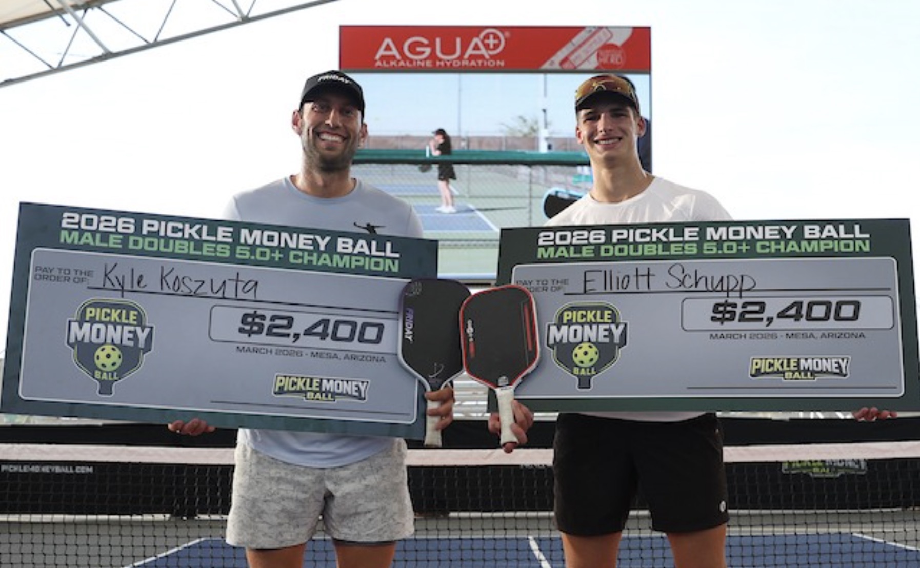 Winners from the first-ever Pickle Money Ball event pose for a photo with their winning checks.