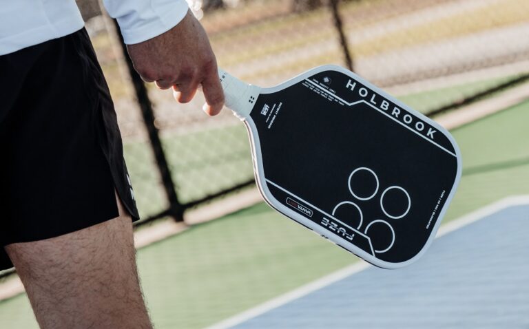 A player holds the new Holbrook Fuze VantaGrit pickleball paddle.